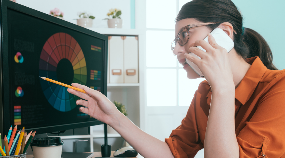 A lady working in an office with a design, representing a graphic designer 